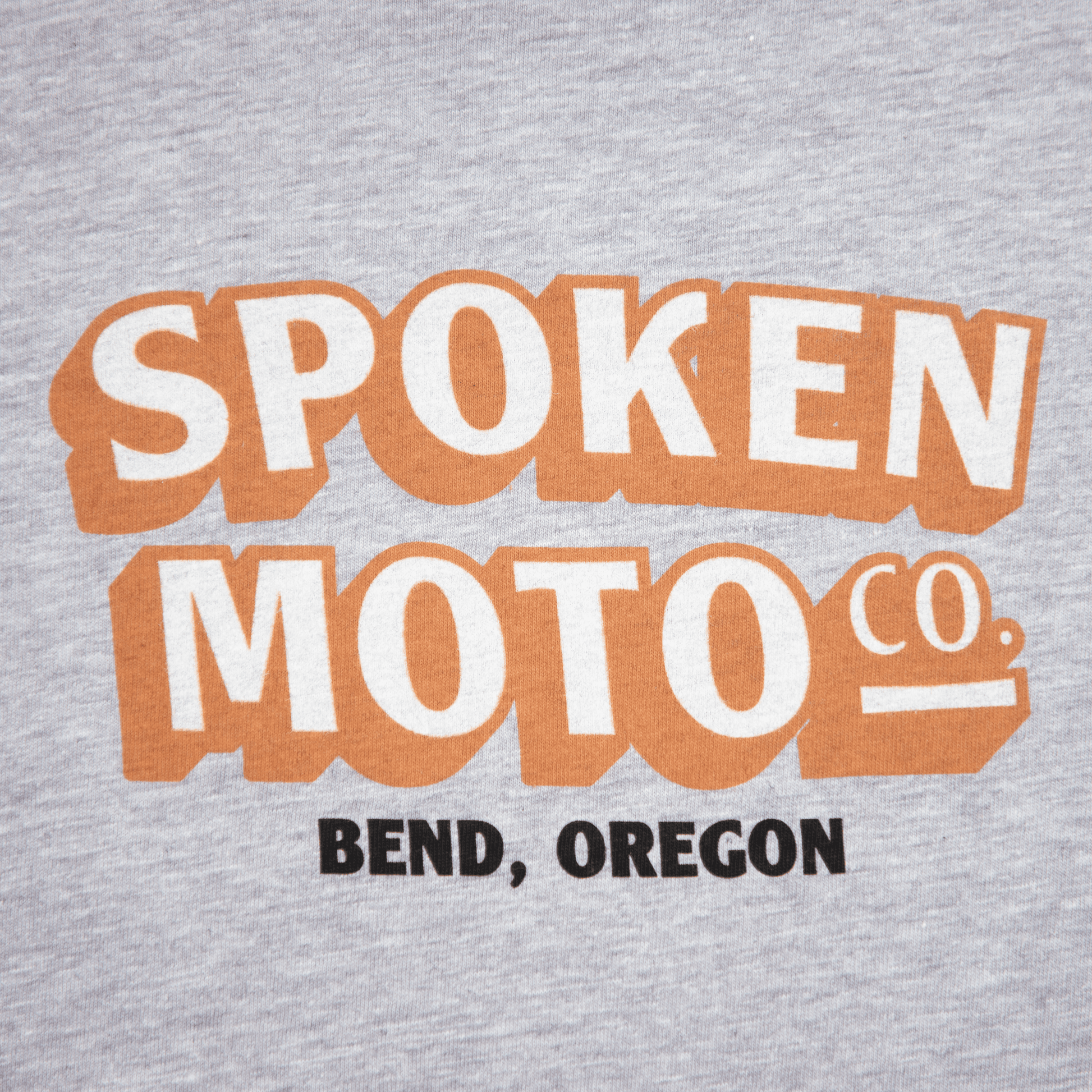 Close up of orange and white Spoken Moto Co. logo with Bend, Oregon.