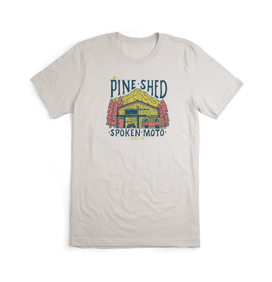 Pine Shed tee from the front: an off-white tee with colorful Pine Shed illustration centered on the chest.